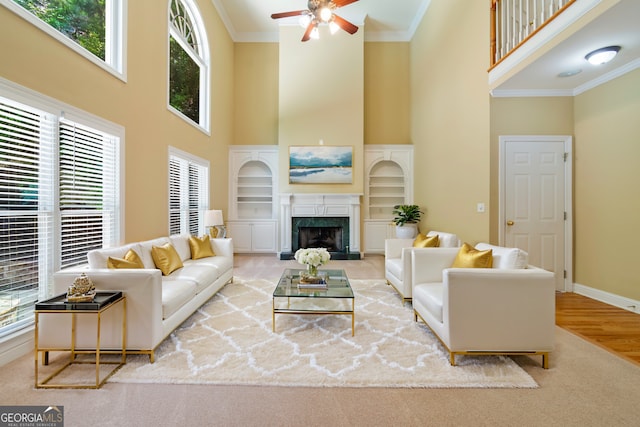 living room with baseboards, ornamental molding, a wealth of natural light, and a high end fireplace