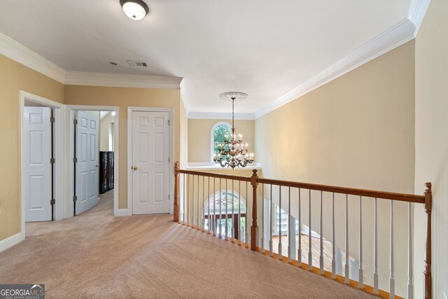 corridor with plenty of natural light, ornamental molding, and light colored carpet