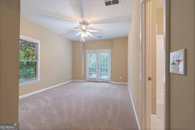 unfurnished room with baseboards, ceiling fan, visible vents, and light colored carpet