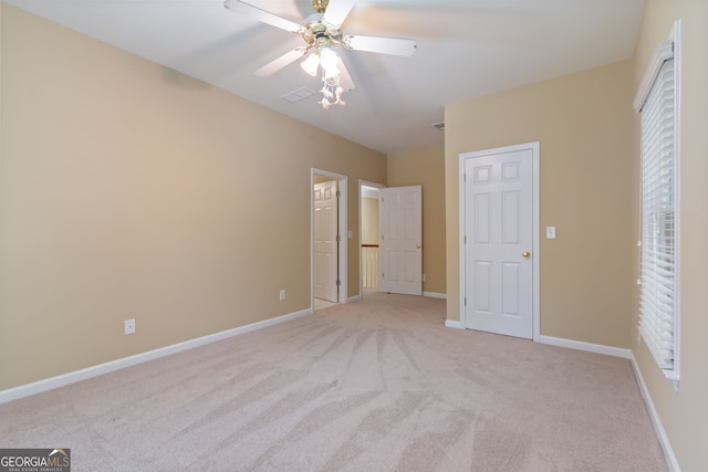 unfurnished bedroom with ceiling fan, visible vents, baseboards, and light colored carpet