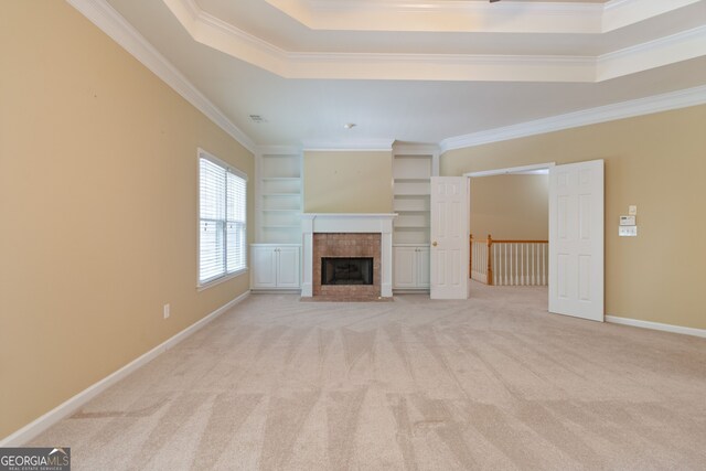 unfurnished living room with ornamental molding, a tile fireplace, and light colored carpet