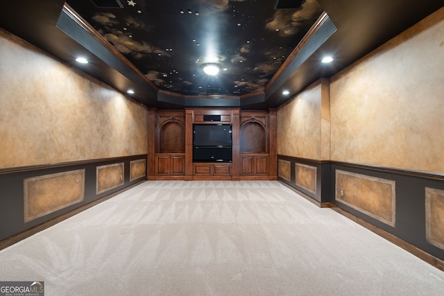 cinema featuring recessed lighting, light carpet, a decorative wall, a tray ceiling, and crown molding