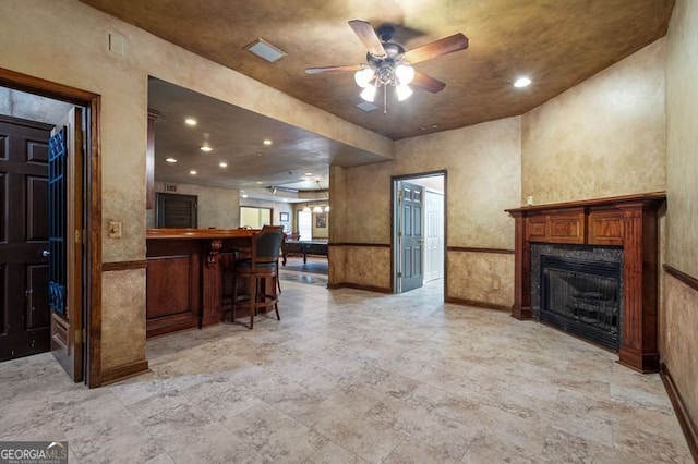 interior space with baseboards, a ceiling fan, open floor plan, a fireplace, and recessed lighting