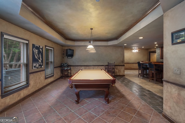 recreation room with pool table, a community bar, ornamental molding, wainscoting, and a raised ceiling