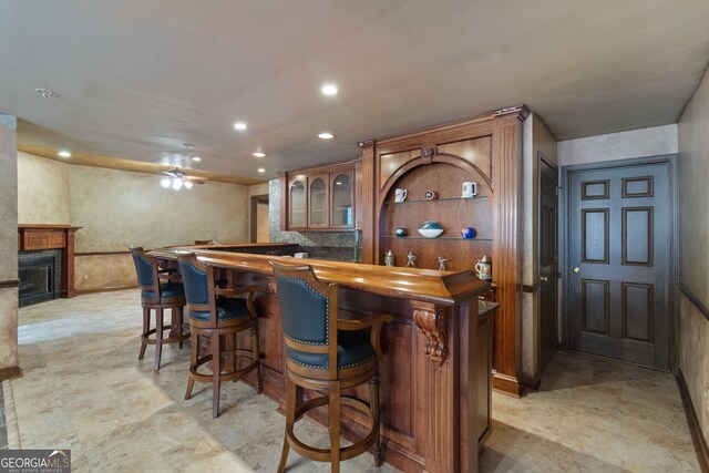 bar with light tile patterned floors and ceiling fan