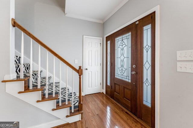 entryway featuring hardwood / wood-style flooring and ornamental molding