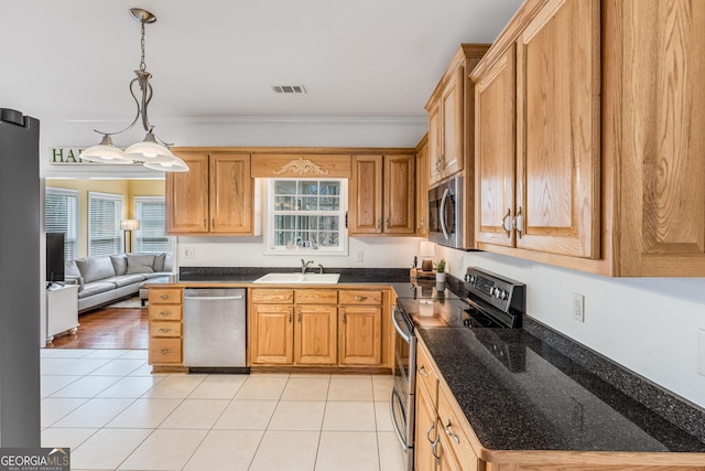 kitchen with decorative light fixtures, stainless steel appliances, crown molding, sink, and light hardwood / wood-style flooring