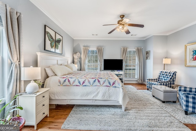 bedroom with crown molding, ceiling fan, and light hardwood / wood-style floors