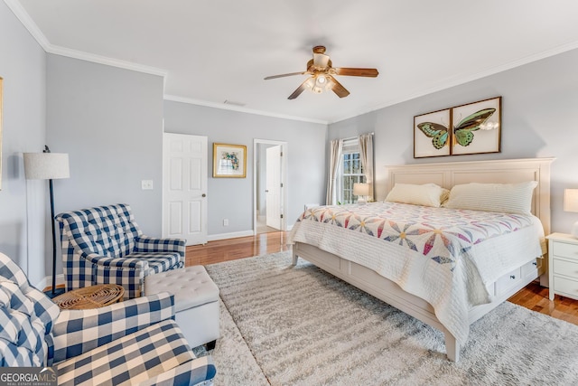 bedroom featuring ornamental molding, wood finished floors, a ceiling fan, and baseboards