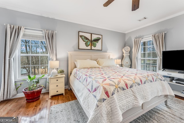 bedroom featuring ceiling fan, hardwood / wood-style floors, and crown molding