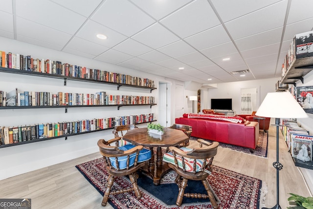 dining area with visible vents, wood finished floors, a paneled ceiling, and baseboards