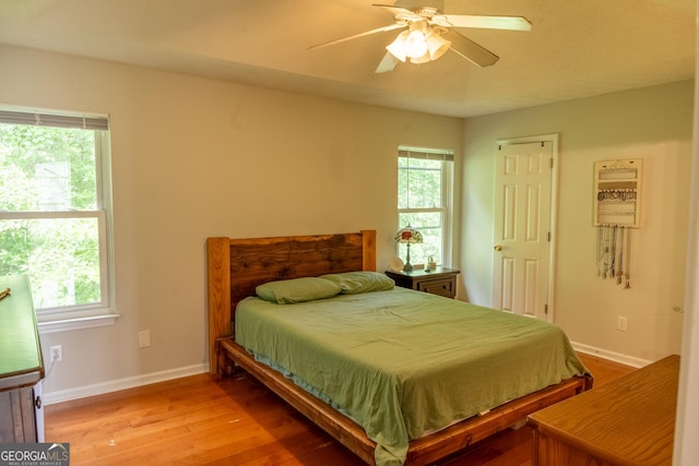 bedroom featuring multiple windows, ceiling fan, and light hardwood / wood-style floors