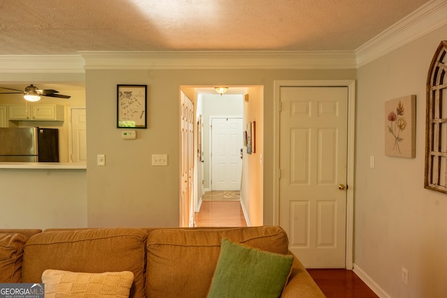 living room with hardwood / wood-style floors, crown molding, a textured ceiling, and ceiling fan