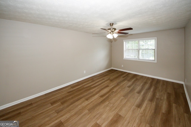 empty room featuring ceiling fan, hardwood / wood-style flooring, and a textured ceiling