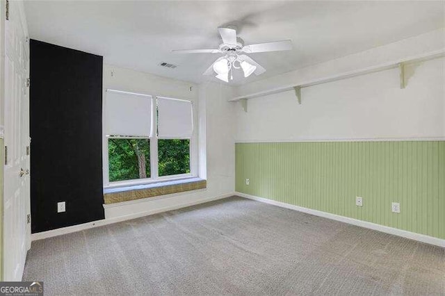 carpeted spare room with ceiling fan, visible vents, and baseboards