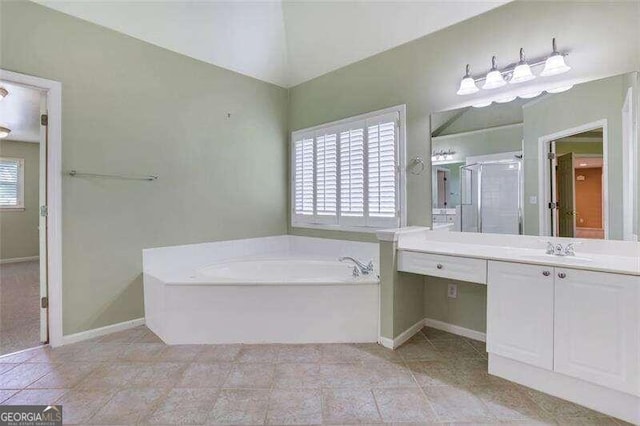 bathroom featuring vanity, baseboards, a shower stall, a bath, and tile patterned floors