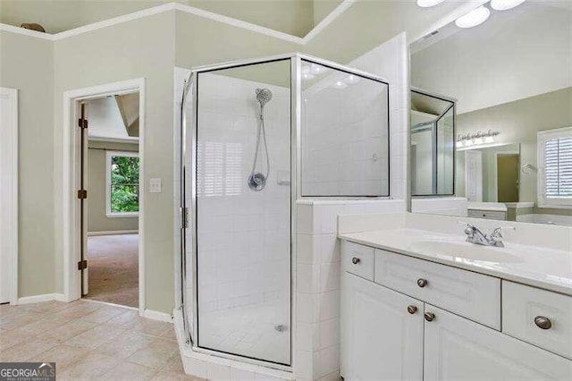 bathroom with ornamental molding, a stall shower, vanity, tile patterned flooring, and baseboards