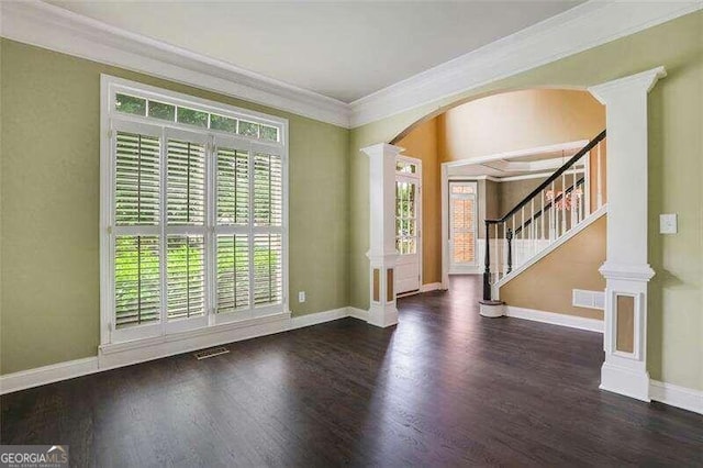 interior space with decorative columns, baseboards, crown molding, and wood finished floors