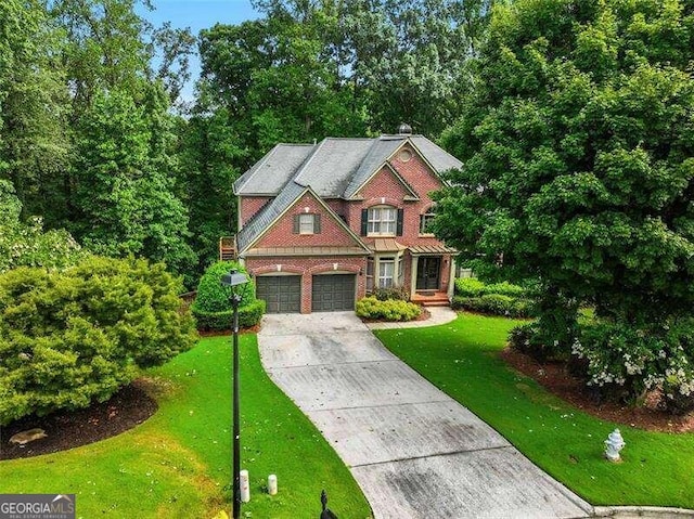 view of front of property with a garage, driveway, brick siding, and a front yard