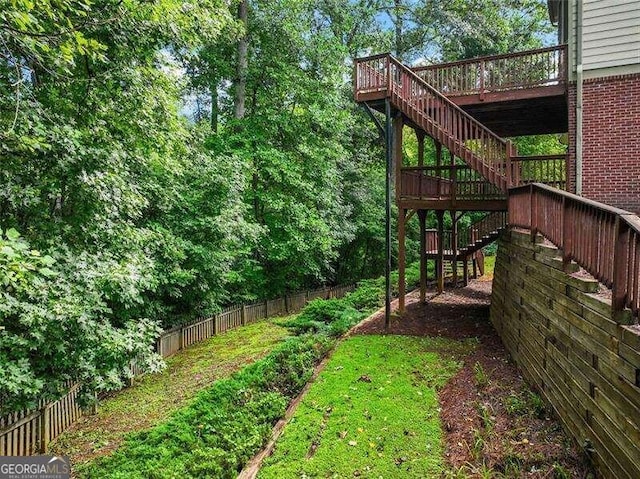 view of yard featuring fence, stairway, and a deck