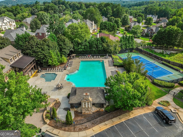 view of swimming pool with a patio area, fence, and a residential view