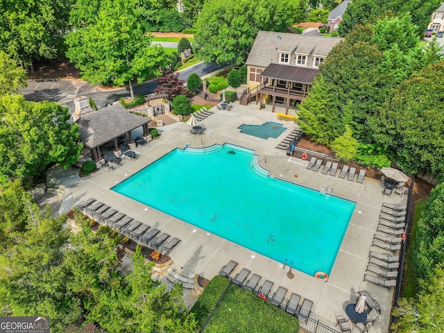 community pool with stairs, a patio, and fence