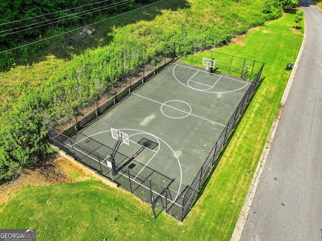 view of basketball court featuring community basketball court, fence, and a lawn