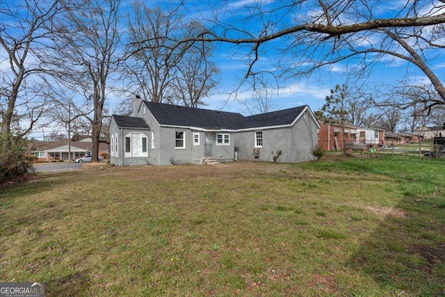 rear view of property with a lawn