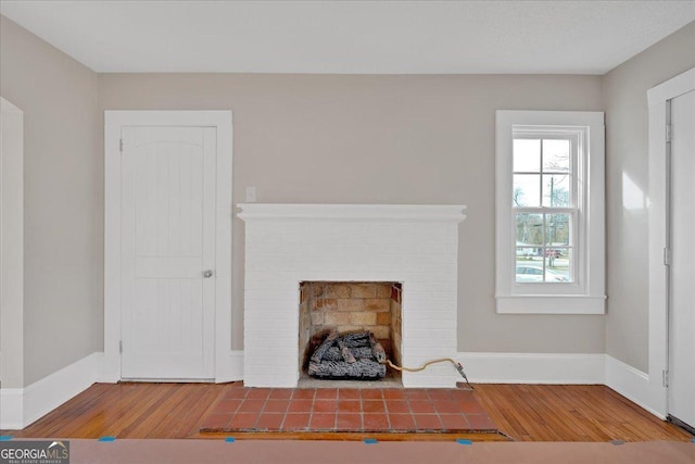 unfurnished living room featuring wood-type flooring and a fireplace