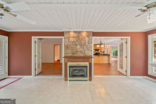 unfurnished living room with ceiling fan, wood ceiling, a fireplace, and light hardwood / wood-style flooring