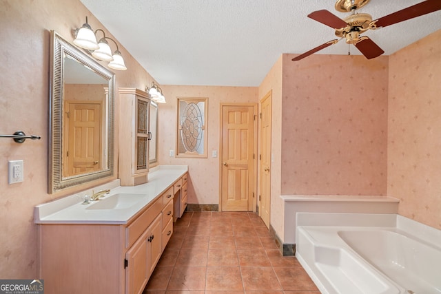 bathroom featuring tile patterned floors, a bathing tub, vanity, ceiling fan, and a textured ceiling