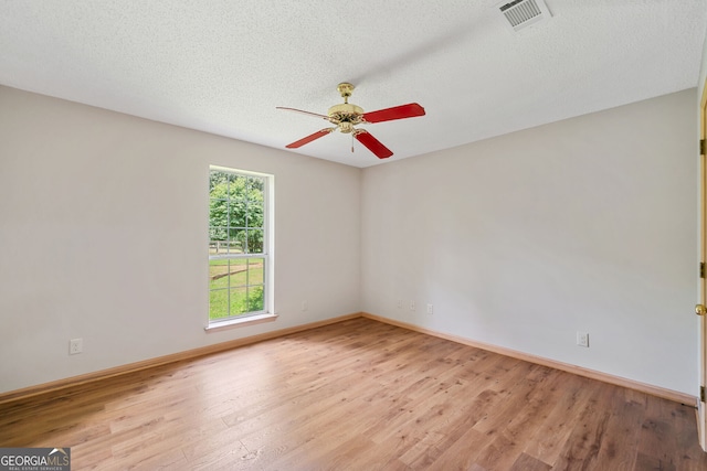 spare room with a textured ceiling, ceiling fan, and light hardwood / wood-style floors