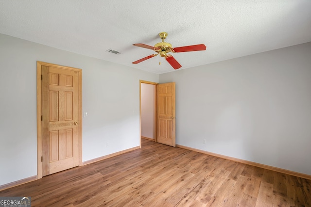 unfurnished bedroom featuring light wood-type flooring, ceiling fan, and a textured ceiling