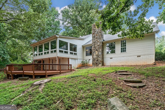 rear view of house with a sunroom and a deck