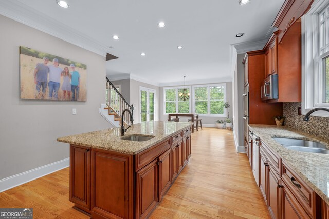 living room featuring built in features, light hardwood / wood-style flooring, ceiling fan, and crown molding