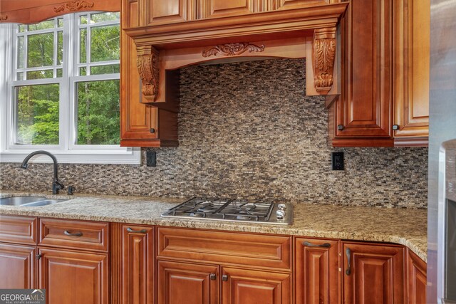 kitchen featuring stainless steel appliances, sink, pendant lighting, light wood-type flooring, and an island with sink