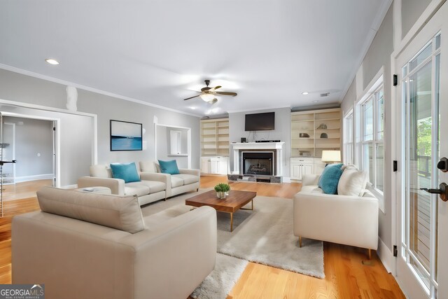 dining space featuring a healthy amount of sunlight, light hardwood / wood-style floors, a notable chandelier, and ornamental molding