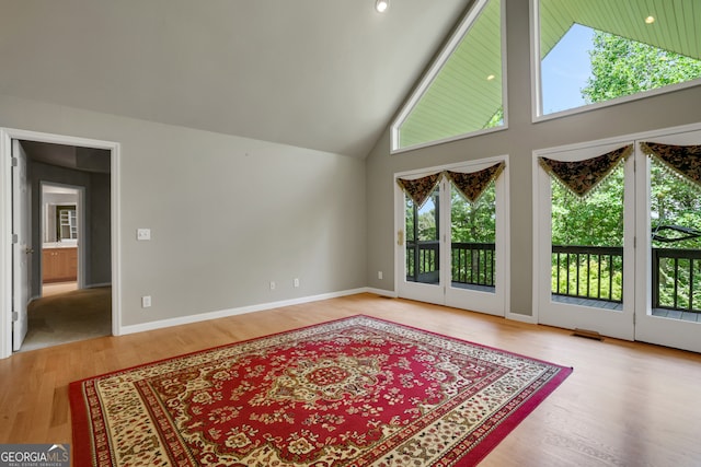 living room with high vaulted ceiling and light wood-type flooring