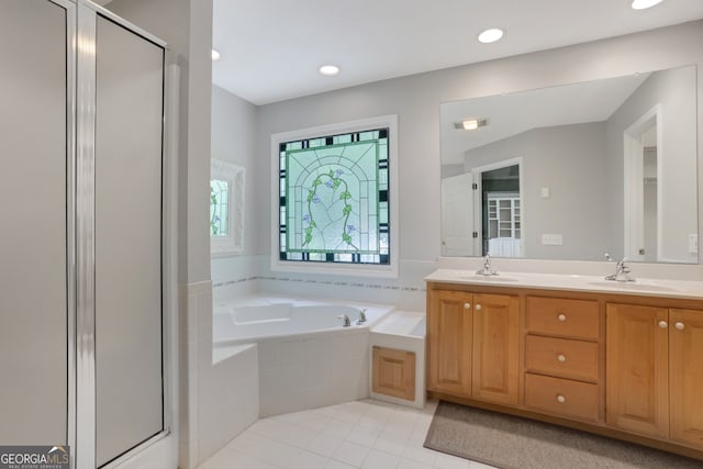 bathroom with plus walk in shower, tile patterned flooring, and double sink vanity