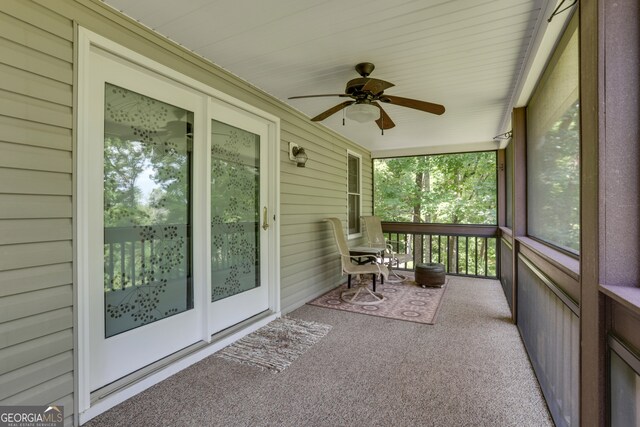 unfurnished sunroom with ceiling fan