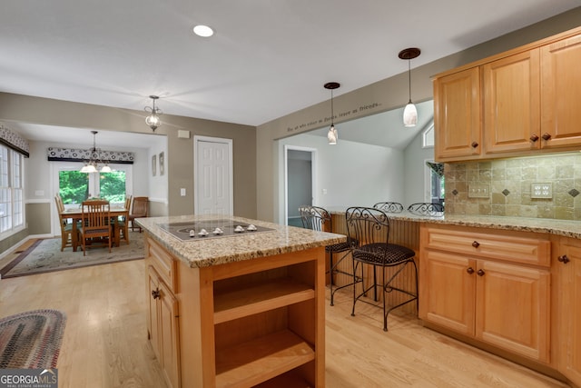 kitchen featuring light hardwood / wood-style floors, light stone countertops, and tasteful backsplash