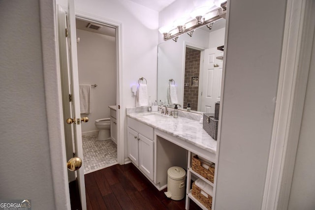 bathroom with hardwood / wood-style flooring, vanity, and toilet