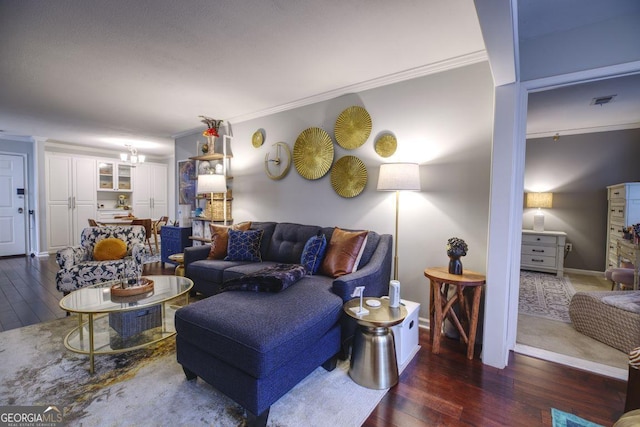 living room featuring dark hardwood / wood-style floors, crown molding, and a chandelier