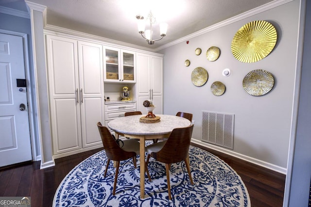 dining area featuring a notable chandelier, ornamental molding, and dark wood-type flooring