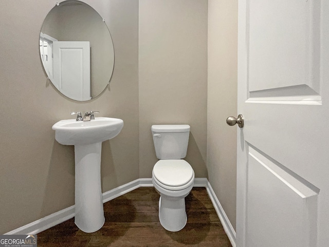 bathroom featuring hardwood / wood-style flooring and toilet