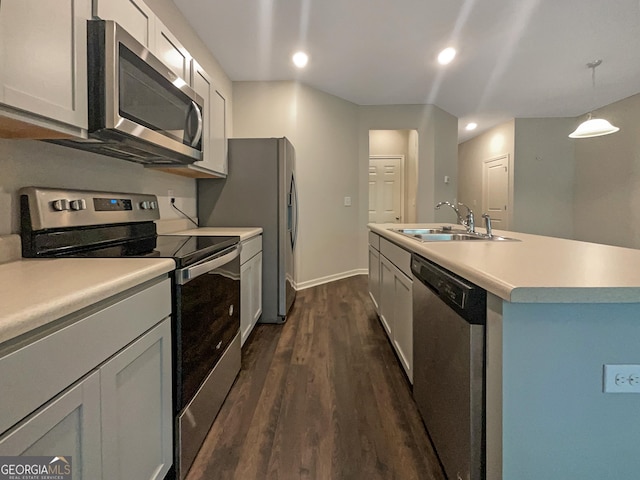 kitchen featuring sink, white cabinetry, decorative light fixtures, stainless steel appliances, and a kitchen island with sink