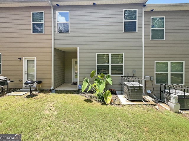 rear view of property featuring central AC, a yard, and a patio