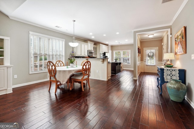 dining room with crown molding and dark wood-type flooring