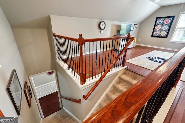 stairs featuring hardwood / wood-style flooring and vaulted ceiling