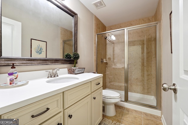 bathroom with vanity, toilet, tile patterned flooring, and a shower with door